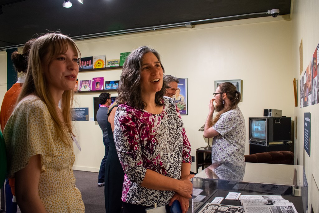 Emily talks to a visitor about her timeline during the opening night of the WKAR exhibition.